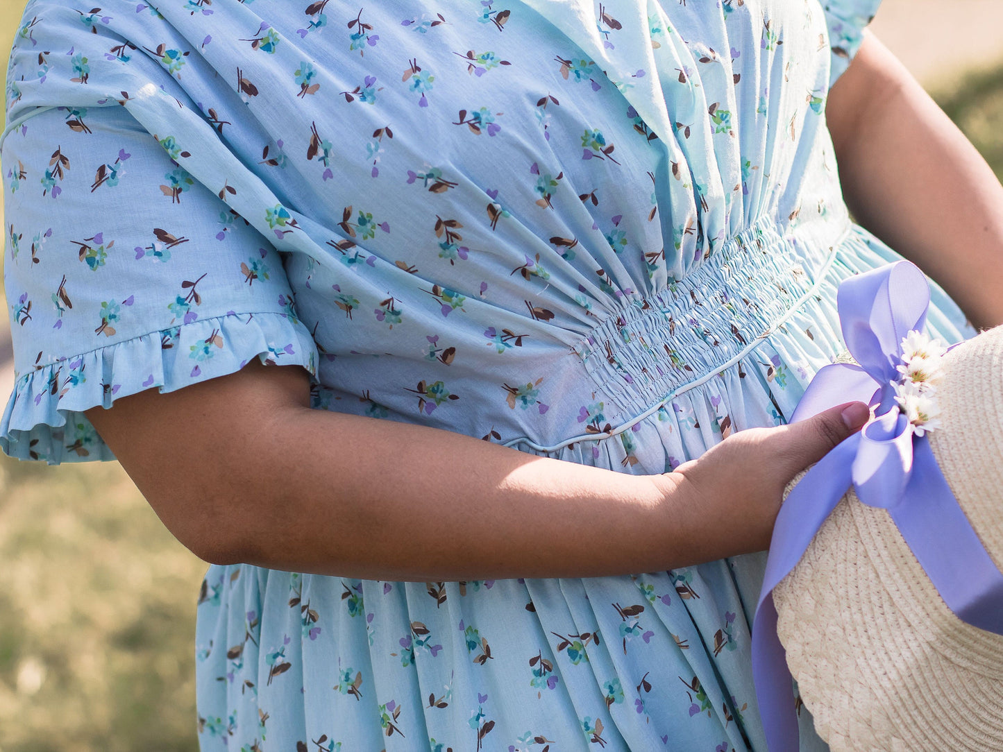 A model wears a blue Victorian fan dress with piping at the armscyes and waist.