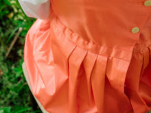 Load image into Gallery viewer, A close-up shows pleats in the back skirt of a salmon-colored Regency petticoat
